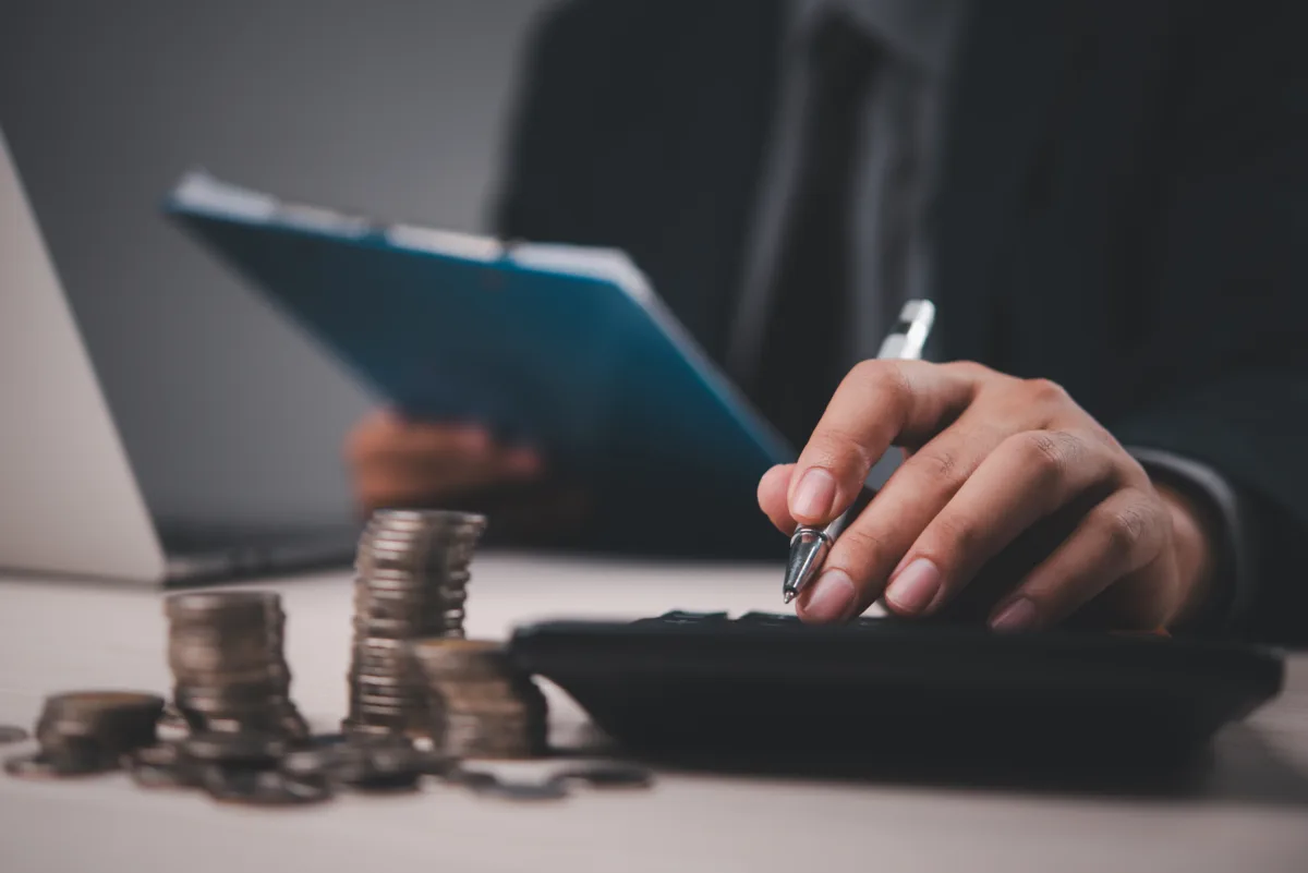 Business owner plans a local marketing strategy behind a stack of coins