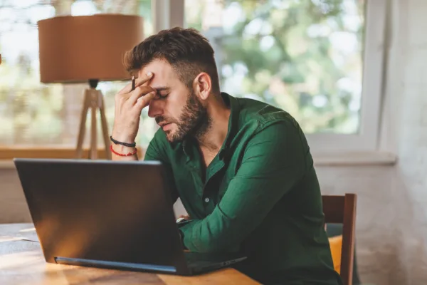 Local business Owner sits in front of a laptop looking frustrated with their website