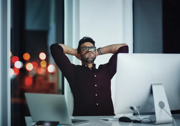 Frustrated business owner leans back and sighs heavily while looking at their underperforming business website that doesn't bring in new clients.