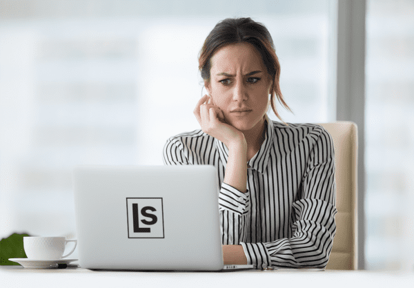 Local Business Owner stares critically at her website on a laptop, trying to decide if it needs improvement