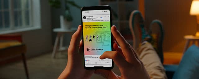 A potential client leans back on a couch, scrolling a digital advertisement on his smartphone